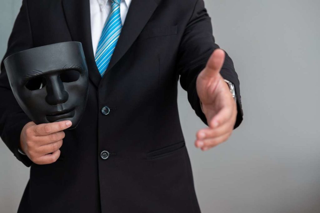 business-man-with-black-mask-covering-insincerity-doing-business-together (1)