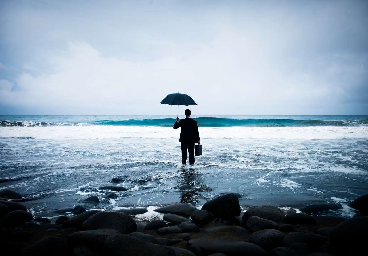 businessman-standing-with-umbrella-ocean (1)