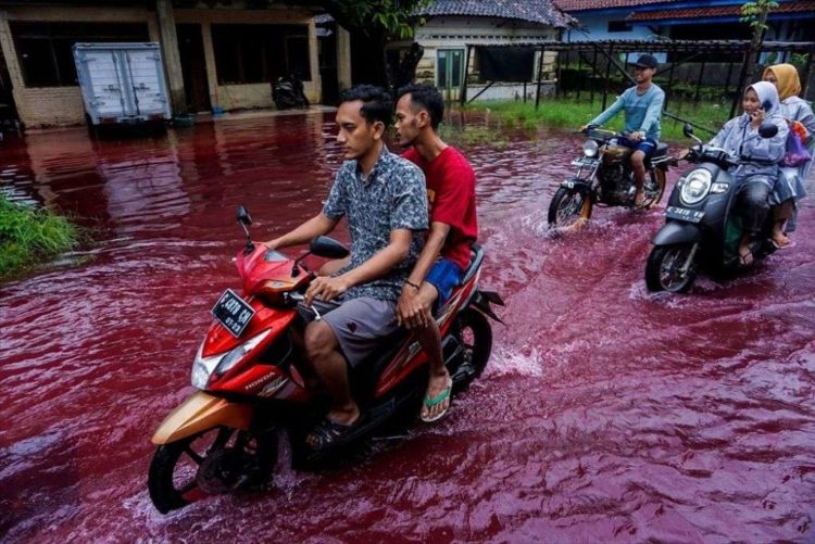 Απο έναν κόκκινο ποταμό «πν ένα χωριό στην Ινδονησία.