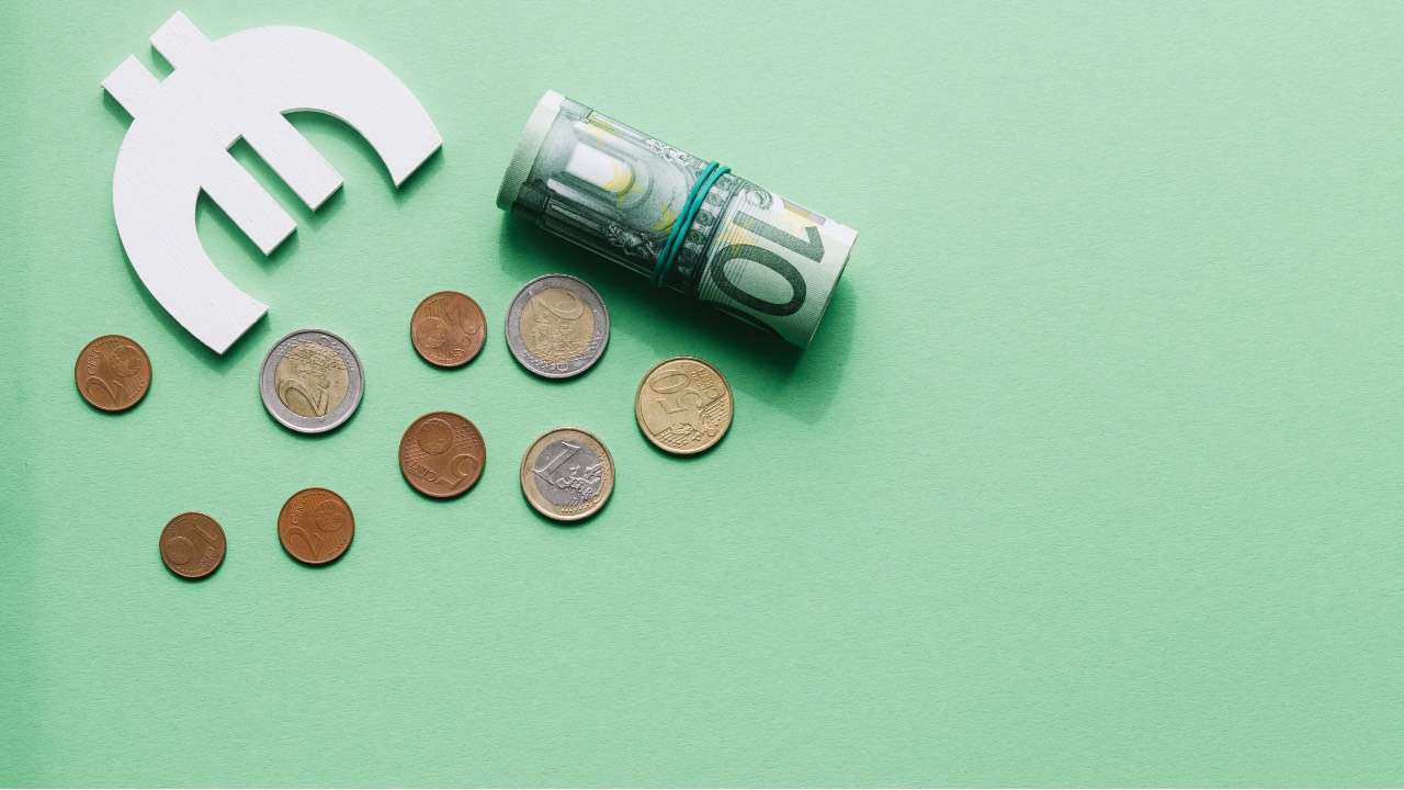 overhead-view-rolled-up-hundred-euro-note-with-symbol-coins-green-surface-2