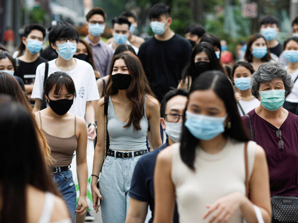 FILE PHOTO: People cross a street at the shopping district of Orchard Road as the city state reopens the economy, amid the coronavirus disease (COVID-19) outbreak, in Singapore