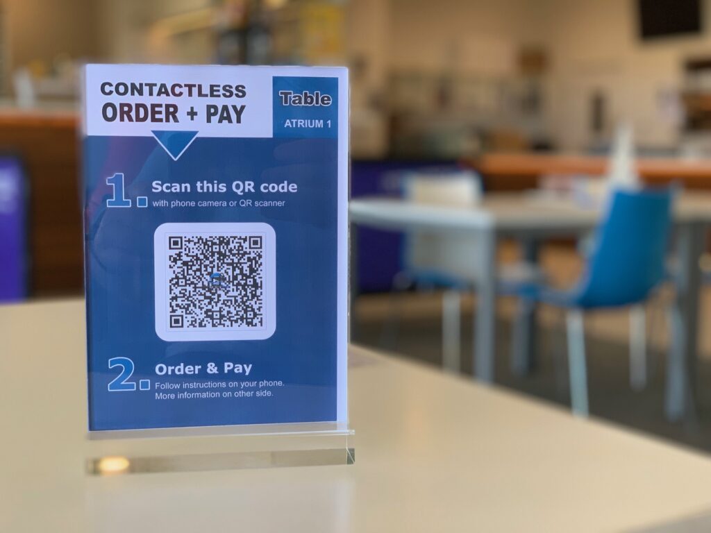 Σε ραγδαία αύξηση της ανεργίας οδηγεί η υιοθέτηση των αυτοματοποιημένων εργαλείων όπως το QR με πρόσχημα την πανδημία, σύμφωνα με τους Financial Times. Η Alexa Allamano συνήθιζε να πληρώνει υπάλληλο για το κατάστημα κοσμημάτων Whidbey Island που διατηρεί στην Ουάσινγκτον για να κάθεται στο ταμείο και να «χτυπά» τα προς πώληση προϊόντα. Oταν, όμως, άνοιξε ξανά το μαγαζί της, μετά το lockdown τον Οκτώβριο του 2020, αυτή η δουλειά γινόταν με κωδικούς QR. Εστιατόρια πειραματίζονται με κωδικούς QR Η Allamano αναδιαμόρφωσε το κατάστημά της έτσι, ώστε οι πελάτες να μπορούν με τα smartphone τους να σαρώνουν τους κωδικούς QR δίπλα σε κάθε είδος που προσφέρεται προς πώληση. Τώρα οι πελάτες έρχονται στο κατάστημα μόνο για να παραλάβουν παραγγελίες, δεν χρειάζεται να ενημερώνει κάποιος για τις τιμές, αναφέρει η ιδιοκτήτρια του καταστήματος. Η αλήθεια είναι ότι οι επιχειρήσεις στρέφονται όλο και περισσότερο σε αυτοματοποιημένα εργαλεία εξυπηρέτησης πελατών. Αλλά αντί για ρομπότ, οι κωδικοί QR αντικαθιστούν τους ανθρώπους. Πολλά εστιατόρια έχουν αρχίσει να πειραματίζονται με κωδικούς QR και συστήματα διαχείρισης παραγγελιών. Το ίδιο συμβαίνει στα περίπτερα και τα παντοπωλεία. Στις ΗΠΑ, περίπου 1,7 εκατ. θέσεις εργασίας στον τομέα της αναψυχής και της φιλοξενίας και αλλά και 270.000 θέσεις εργασίας στη λιανική είναι απίθανο να αποκατασταθούν. Οι οικονομολόγοι λένε ότι η Εργασία, ως τομέας της οικονομίας, έκανε άλματα κατά τη διάρκεια της οικονομικής ύφεσης, καθώς τα στενότερα περιθώρια τους αναγκάζουν να είναι πιο παραγωγικοί με λιγότερους πόρους. Ο αυτοματισμός, όμως, σίγουρα θα έχει θύματα… Οι γυναίκες πιο ευάλωτες από την "QRποίηση" της εργασίας Οι γυναίκες χωρίς πανεπιστημιακό πτυχίο είναι πιο πιθανόν να χάσουν εργασία την εργασία τους, σύμφωνα με έρευνα. Υπενθυμίζεται ότι χιλιάδες διοικητικοί υπάλληλοι και τηλεπωλητές αντικαταστάθηκαν από υπολογιστές κατά τη διάρκεια της οικονομικής κρίσης του 2007, σύμφωνα με έγγραφο της Federal Reserve της Φιλαδέλφειας. Αυτό συνέβη πριν και συμβαίνει ξανά", δήλωσε ο Mark Muro, ανώτερος συνεργάτης στο Ινστιτούτο Brookings. Οι εργοδότες έχουν επικεντρωθεί στη χρήση αυτοματισμών για την επιτάχυνση των διαδικασιών στα κέντρα διανομής και στις αλυσίδες εφοδιασμού. Ωστόσο, η κρίση της Covid οδήγησε στην προσαρμογή των αυτοματοποιημένων εργαλείων στον τομέα της εξυπηρέτησης πελατών, καθώς τόσο οι καταναλωτές όσο και οι ιδιοκτήτες επιχειρήσεων προσπάθησαν να μειώσουν τις διαπροσωπικές επαφές.