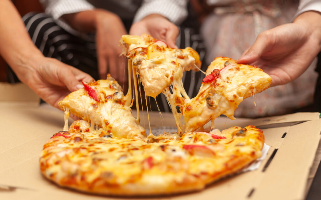 Hands,Of,Colleague,Or,Friends,Eating,Pizza,After,A,Long