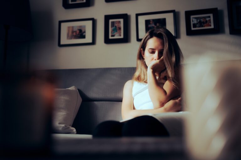 Sad,Depressed,Woman,Alone,At,Home,Sitting,On,A,Sofa.